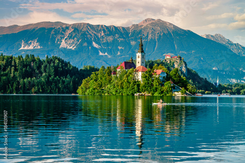 Evening views on the lake Bled with the famous Pilgrimage Church of the Assumption of Maria and Bled Castle and Julian Alps at background