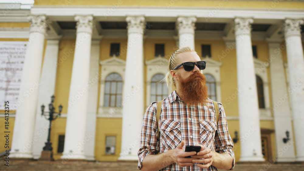 Bearded tourist man lost in city and using smartphone online map to find right directions