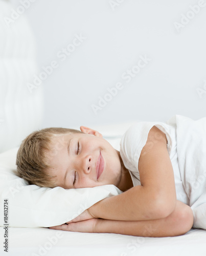 Happy little boy sleeping in bed. Space for text