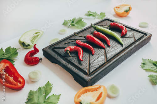 food, healthy eating and nutrition concept - sliced pumpkin and other vegetables on wooden board. Fresh vegetables and greens on a wooden board. photo