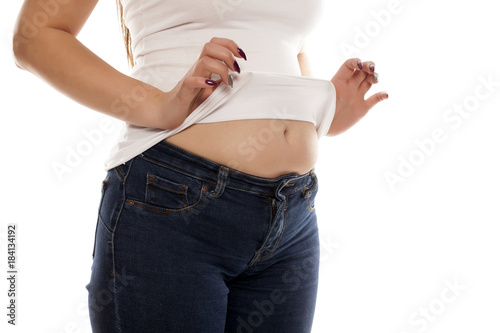 the woman shows her stomach that has risen from overeating