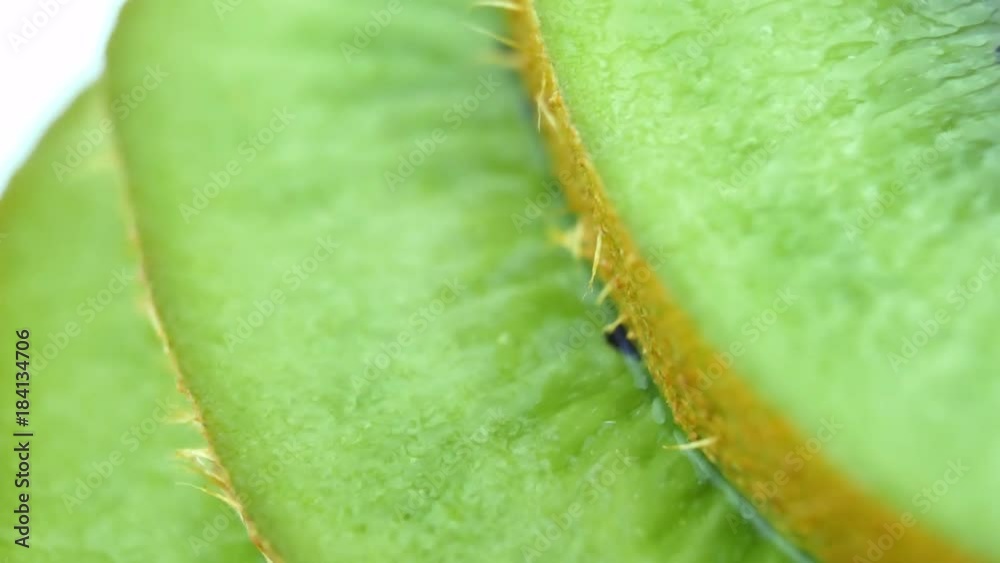 Slice of fresh kiwi fruit isolated. Macro of juicy kiwi rotates as background. Slice of fresh kiwi fruit isolated. Macro of juicy kiwi rotates as background.