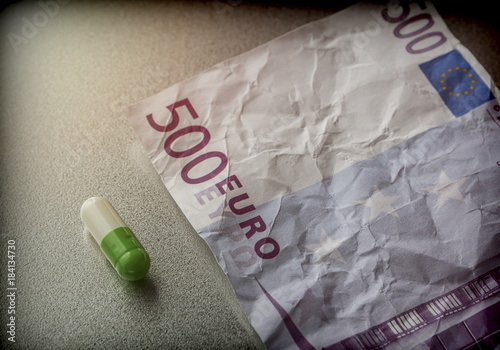 Capsule of white and green on a ticket used 500 euros, conceptual image
