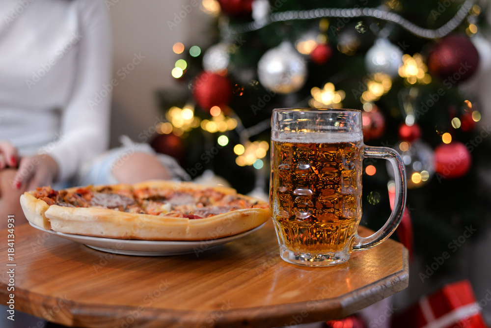 Girls eat pizza and talk in New Year's Night. Girls drink beer and eat pizza in front of Christmas tree