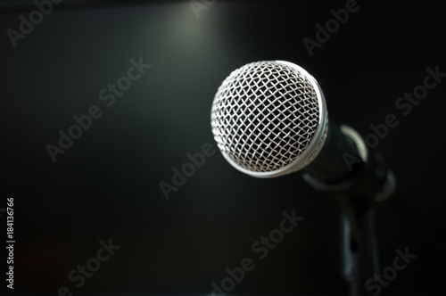 Retro Microphones on front stage in pub bar or restaurant. Classic sing a song in evening and night show on black light background. © smolaw11