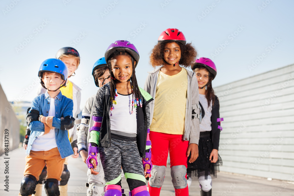 Obraz premium Group of happy sporty kids rollerblading outdoors