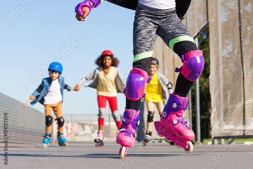 Kids rollerblading in protective gear outdoors