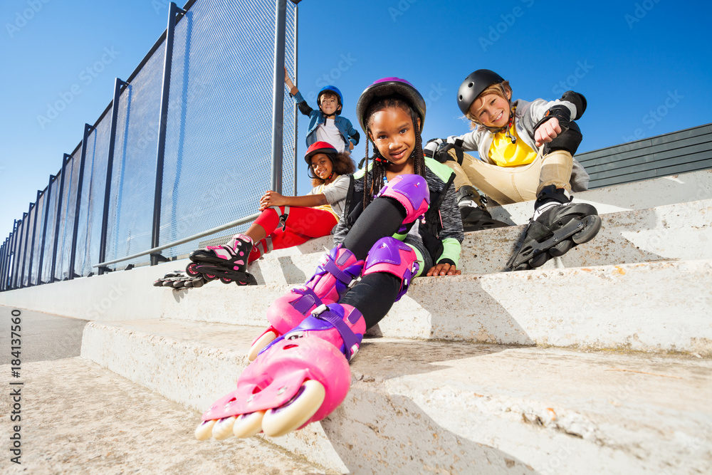 Girl in roller skates sitting with friends
