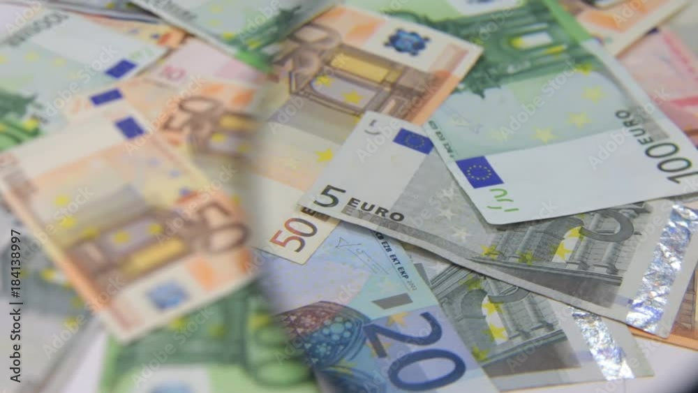 Study of a rotating background of euros using a magnifying glass. Study of a rotating background of euros using a magnifying glass.