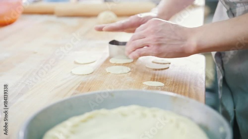 Cook is baking, forming and decorating pie in the bakery, preparation of ornaments photo