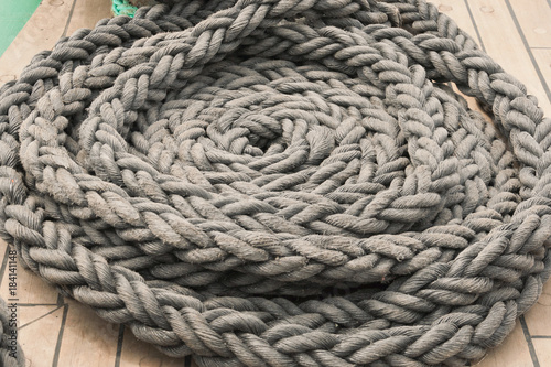 Gray sea rope, folded in a circle close-up on the ship's deck.