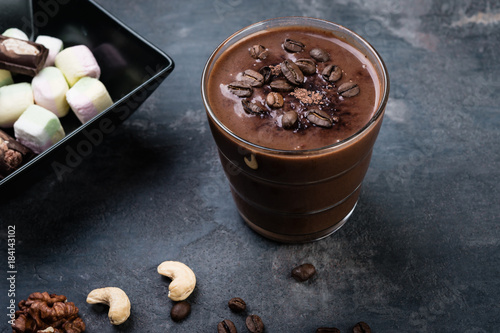 Chocolate smoothie with nuts and marshmallow on dark background
