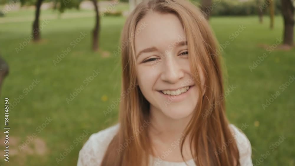 Young girl while walking in the park touches the touch screen of a smart clock. Active lifestyle. Sport. Recreation. Summer. Young girl while walking in the park touches the touch screen of a smart clock. Active lifestyle. Sport. Recreation. Summer.