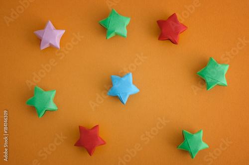 Colorful origami lucky stars on yellow background