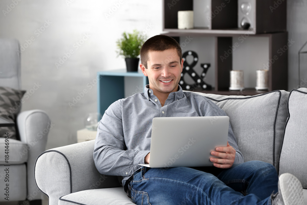 Young man with laptop on sofa at home Young man with laptop on sofa at home