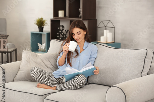 Young woman reading book on...