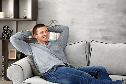 Young man relaxing on sofa ...