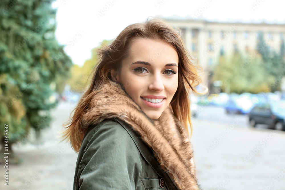 Attractive smiling woman in jacket with fur collar outdoors Attractive smiling woman in jacket with fur collar outdoors