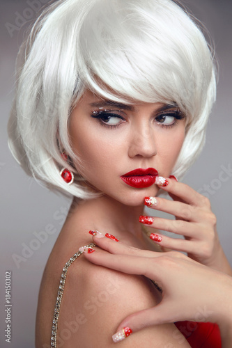 Christmas red lips makeup and Manicured nails. Beautiful blonde girl closeup portrait. White Short bob hairstyle. Sensual blond woman with xmas eye shadow. Vogue style. Studio photo