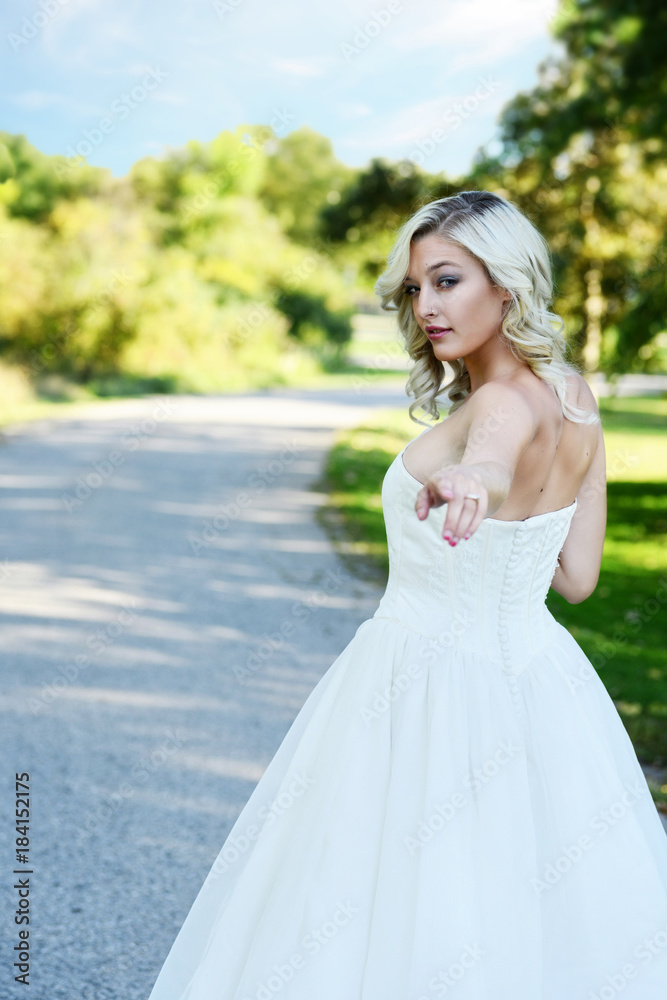 blonde bride follow me walking down garden walkway