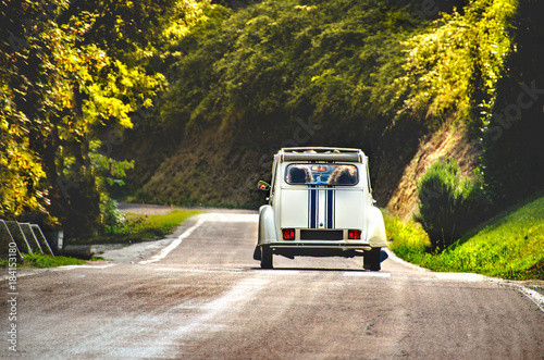 vintage car country winding road back view friends road trip