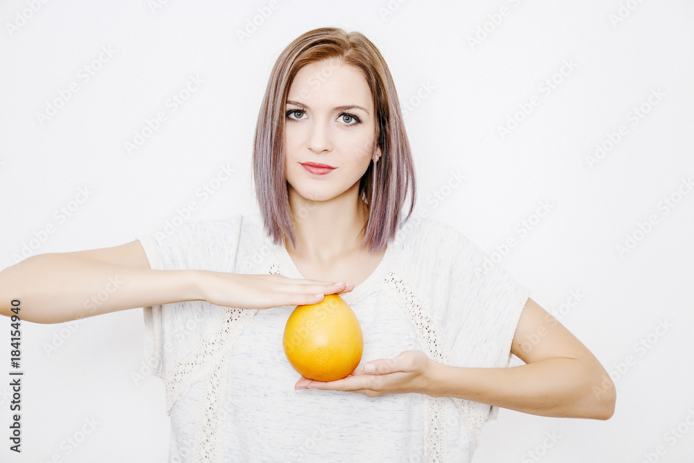 Woman holding a grapefruit in her hands. Young woman with citrus. Woman holding a grapefruit in her hands. Young woman with citrus.