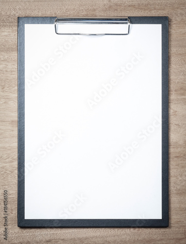 Blank clipboard on wooden background.