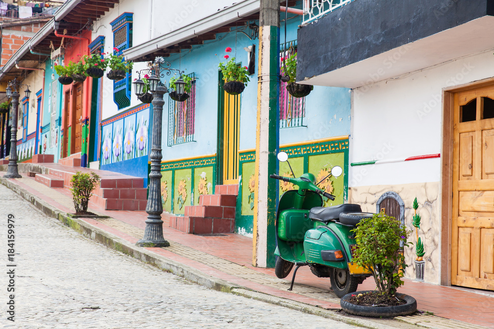 Naklejka premium Green motorcycle at the colorful town of Guatape, Antioquia – Colombia.