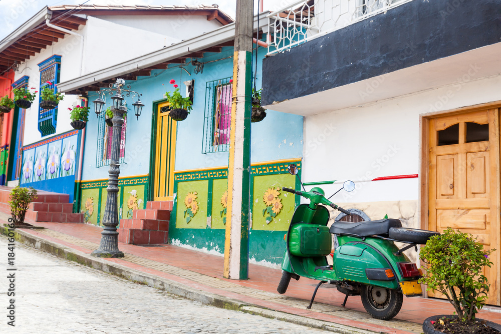 Fototapeta premium Green motorcycle at the colorful town of Guatape, Antioquia – Colombia.