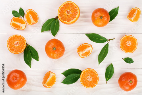 orange or tangerine with leaves on white wooden background. Flat lay, top view. Fruit composition