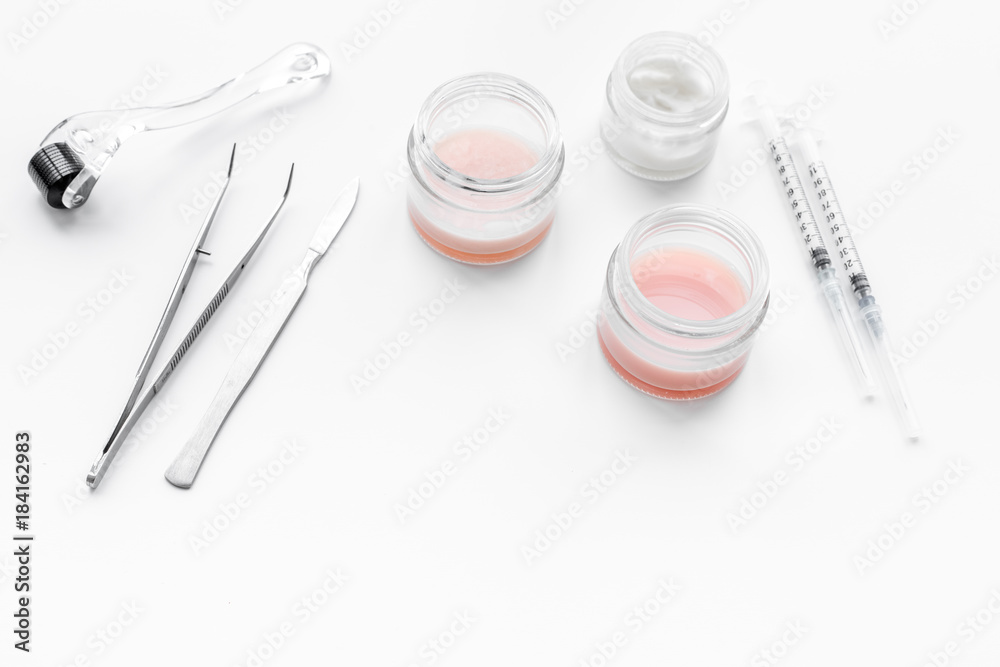 Dermatologist or cosmetologist accessories. Dermaroller, creams and mask, beauty injection, tools on white background copyspace Dermatologist or cosmetologist accessories. Dermaroller, creams and mask, beauty injection, tools on white background copyspace