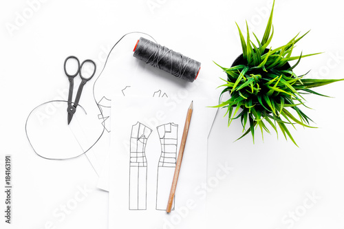 Tailor's work desk. Pattern of clothing and tools on white background top view