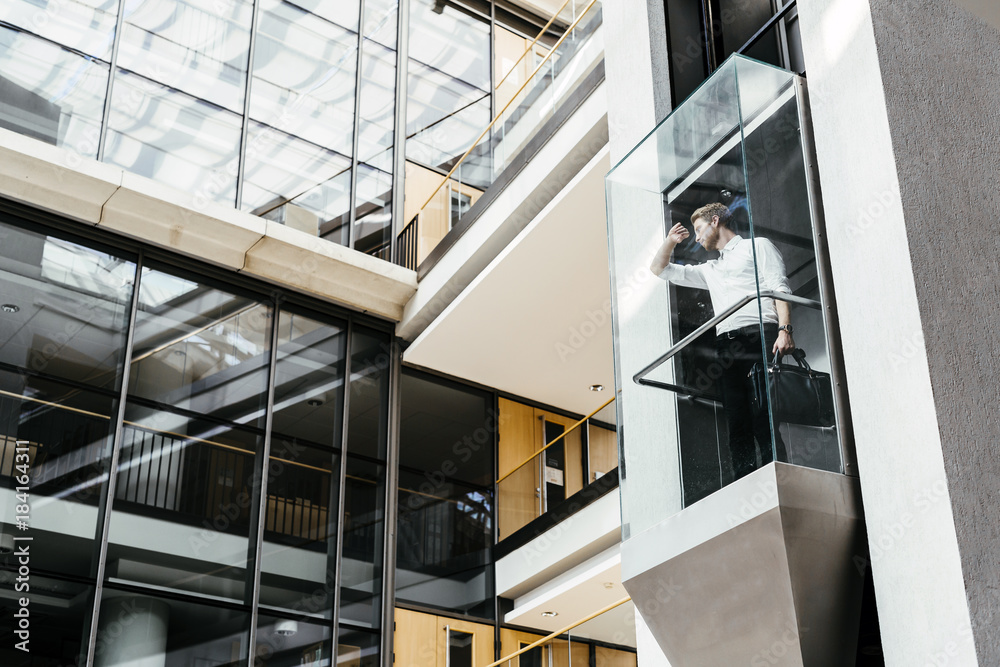 Fototapeta premium Businessman taking the elevator