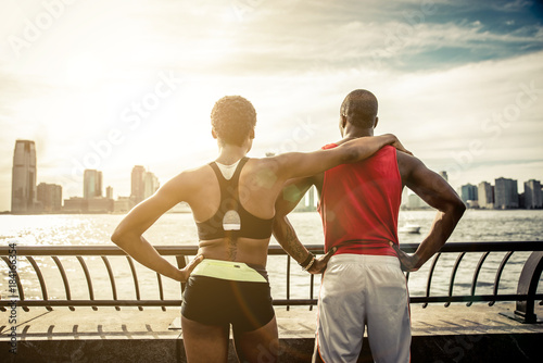 Fototapeta Naklejka Na Ścianę i Meble -  Couple of runners making fitness on New york pier walkway