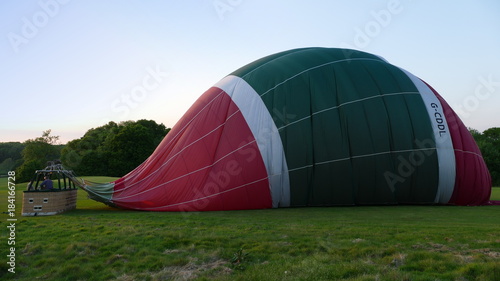 Canvas Print Deflated hot air balloon with basket in a field