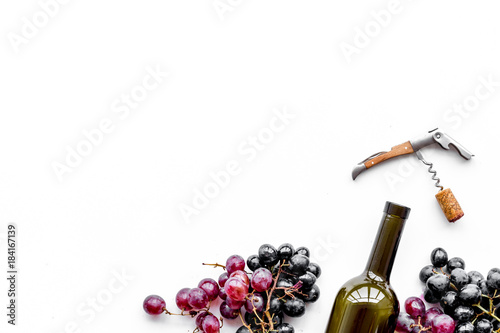 Open the wine. Corkscrew near bottle and grape on white background top view copyspace