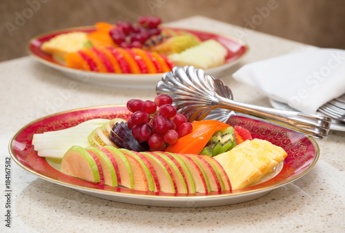 Fruit plate - grapes  apples  pineapple  kiwi  plum. Fruit at a Banquet  festive table  self service.