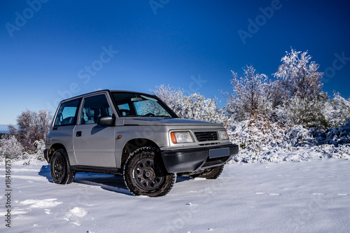 An offroad car on the snow in the mountains