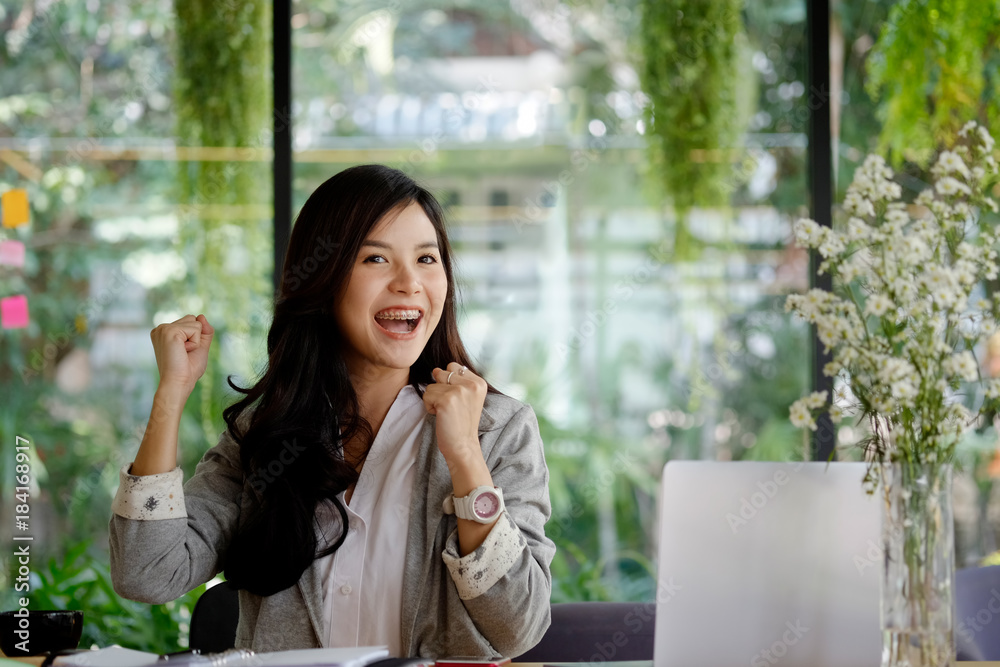 Beautiful Asian girl celebrate with laptop in office. Beautiful Asian girl celebrate with laptop in office.