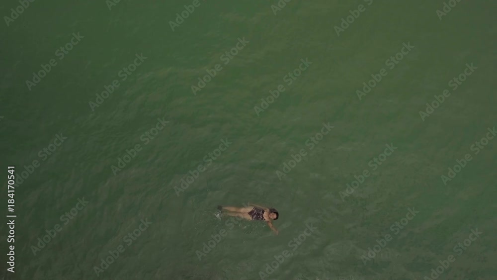 aerial shot woman swimming alone in the sea aerial shot woman swimming alone in the sea