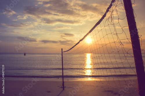 Valleyball net on the beach with beautiful seasacpe view and sunset light in twilight time at Chao Lao Beach, Chanthaburi Province, Thailand. (Selective focus) photo