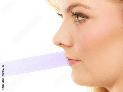 Profile portrait of blonde woman, grey stripe from mouth photo