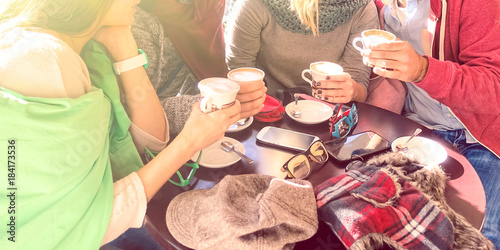Group of best friends drinking coffee at bar cafe - Happy family moments gathering together around table on sunny winter day - Concept of people togetherness with natural sun backlight halo