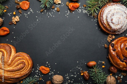 Homemade baked Christmas baked goods on a black background. With icing of sugar snow. Space for text, space for copying.