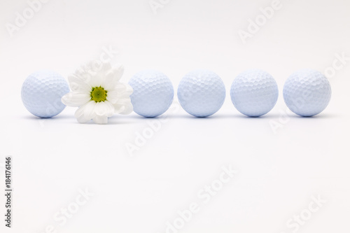 White golf balls and sping flower on the white desk