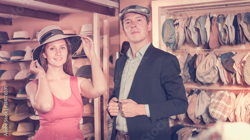 Wallpaper Mural Positive woman and man trying on fashion hats Torontodigital.ca