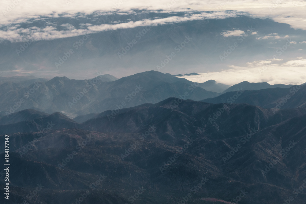 aerial shot from plane flying above the california mountains in daytime
