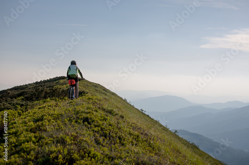 Woman rides bicycle up in the mountains