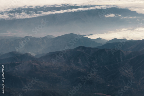 aerial shot from plane flying above the california mountains in daytime