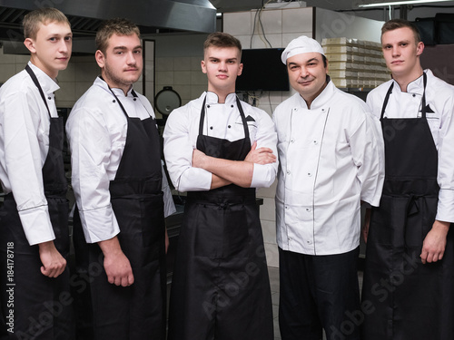 Chef and his team of professional staff at restaurant. Teamwork brings success to any business